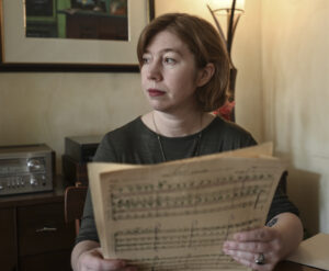 Ruby Fulton in a black shirt, holding older sheet music